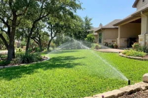Residential lawn sprinkler system watering green grass in Austin TX backyard, showing efficient irrigation system installation and even water distribution for healthy landscape